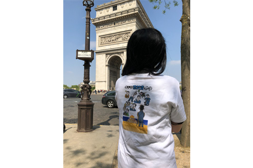 画像：旅行で訪れたパリの凱旋門前で、三愛会から贈られた市村清Tシャツを着て